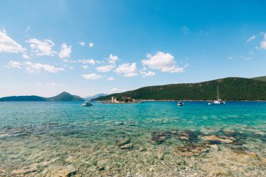 Arkasında dağlar olan Kotor Körfezi 'ndeki Otocic Gospa adası. Karadağ