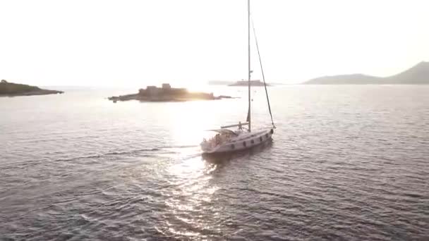 Yate de vela blanco navega más allá de la isla de Zhanic, Montenegro — Vídeo de stock