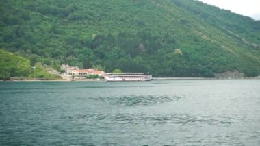 Feribottan bir turist gemisine bak. Körfez boyunca dağların arka planına doğru gidiyor.