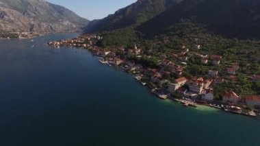 Prcanj kıyısında dağların eteklerinde yeşil ağaçlarla çevrili.