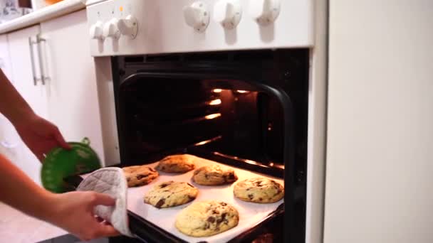 Дівчина виймає готове печиво з печі — стокове відео