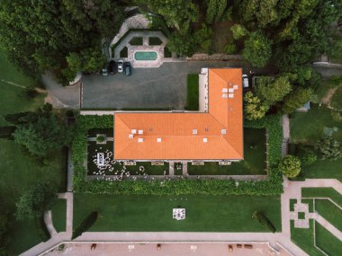 Villa Milocer 'ın önündeki çimenlikte beyazlar içinde bir düğüne davetliler. Üst görünüm