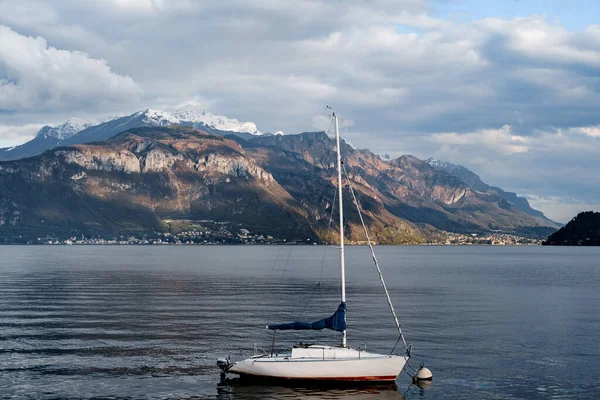 Yacht med en vikta segel mot en bakgrund av berg. Comosjön, Italien — Stockfoto