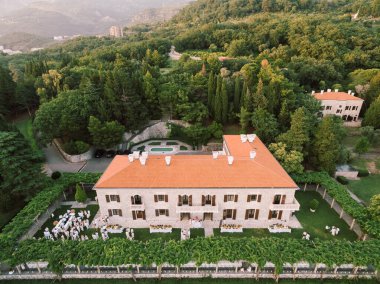 Villa Milocer 'ın önündeki çimenlikte beyazlar içindeki misafirler. Karadağ