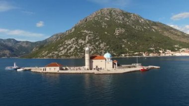 Turistler, Kayalıklar Leydisi Kilisesi 'nin girişinin önünde duruyorlar. Perast, Karadağ