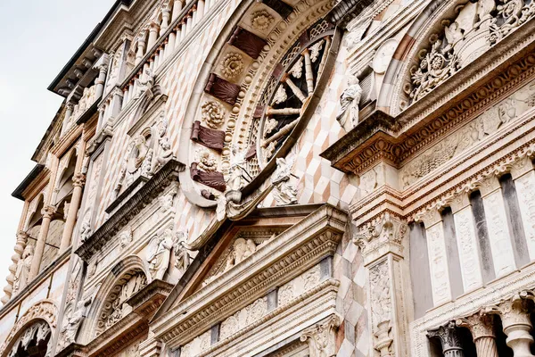 Standbeelden, gesneden mallen, zuilen en rozenvenster op de gevel van de Colleoni Kapel. Bergamo, Italië — Stockfoto