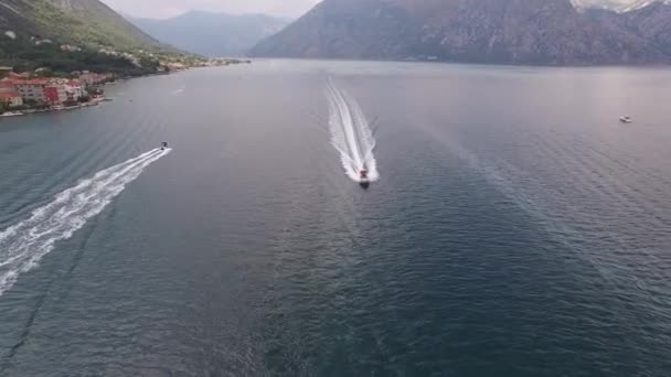 コトル湾に沿ってモーターボートが航行する。空中風景 — ストック動画