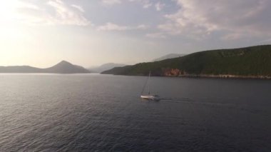 Dağlık sahil boyunca Mamula adasına yelken açan yat.
