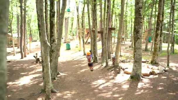 Pojken glider snabbt ner i zip-linjen i äventyrsparken — Stockvideo