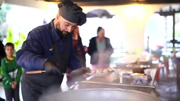 厨师从大锅里取出大蒜头，盘子里放着乌兹别克皮面包 — 图库视频影像