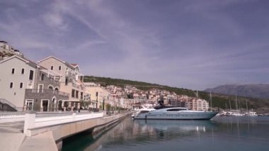 Lustica körfezine demirlemiş tekne ve yatlar dağların arka planına karşı.