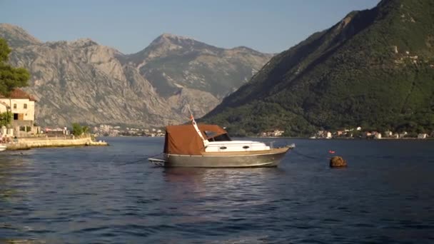 Verankertes Boot vor der Küste von Perast schwankt auf den Wellen — Stockvideo