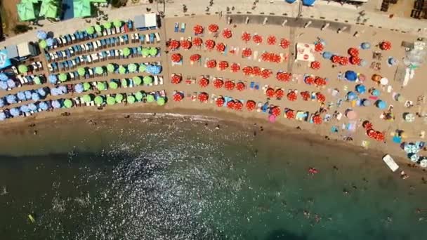 Вид на пляж с зонтиками и лоджиями для загара в Будве. Черногория — стоковое видео