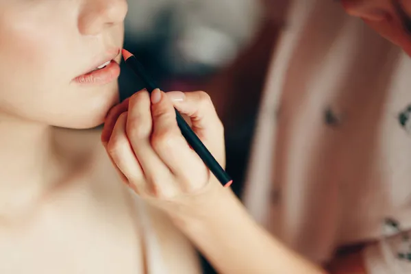 Makyöz, müşterinin dudaklarını kurşun kalemle boyar. Yakın plan. — Stok fotoğraf