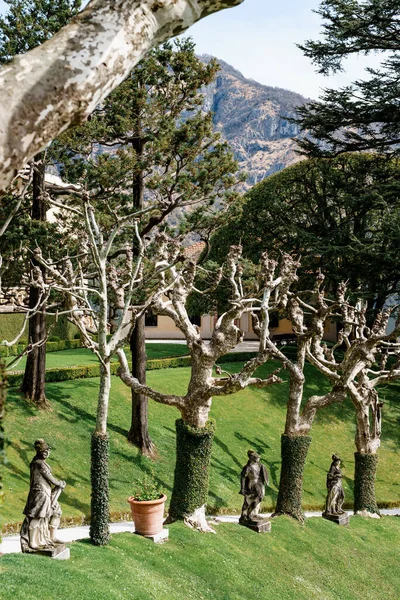 Sculture in pietra tra platani nel parco di Villa Balbianello. Lago di Como, Italia — Foto Stock