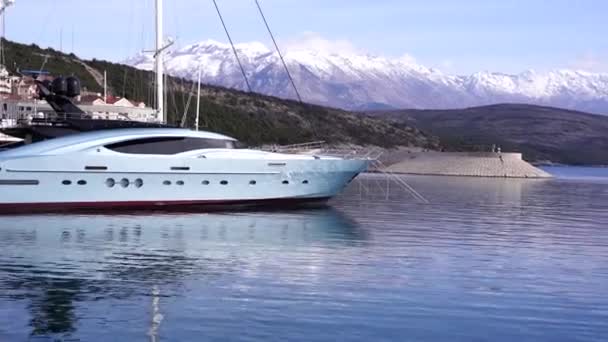 Белая яхта стоит в заливе Луштица на фоне гор — стоковое видео