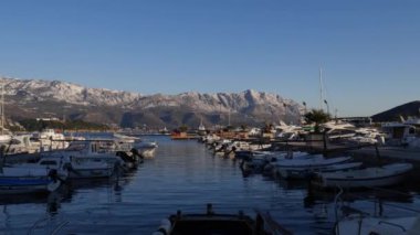 Budva rıhtımının manzarası karlı dağların arka planına karşı
