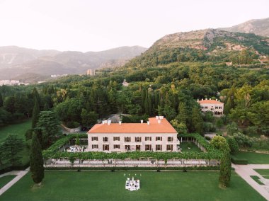 Beyaz sahnede, Villa Milocer yakınlarındaki çimenlikte müzisyenler. Karadağ