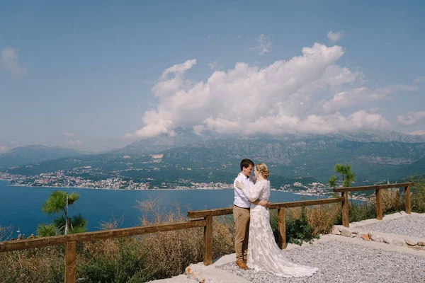 Noiva e noivo abraçando enquanto estava em pé no deck de observação sobre a baía — Fotografia de Stock