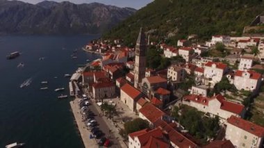 Kırmızı çatılı evlerin arka planına karşı çan kulesi. Perast, Karadağ