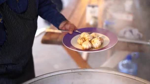 Cook saca las cabezas de ajo del caldero con pilaf con una cuchara ranurada — Vídeo de stock