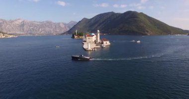 Gospa od Skrpjela adasının panoramik manzarası dağların arka planına karşı