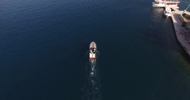 Моторная лодка плывет по морю мимо острова. Вид сверху — стоковое видео