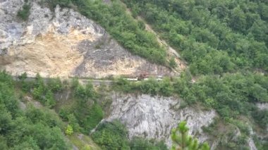 Kamyon Piva Gölü 'nün yukarısındaki dağ yolunda kereste taşıyor.