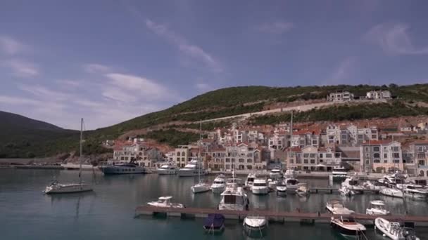 Vista de barcos ancorados contra o pano de fundo de belas casas no porto de Lustica — Vídeo de Stock