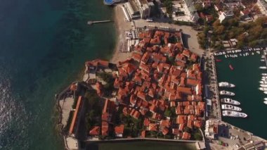 Budva 'daki eski evlerin kırmızı çatıları iskelenin arka planına karşı. İHA