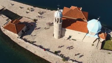Turistler Gospa od Skrpjela adasında dolaşıyorlar. Kotor Körfezi