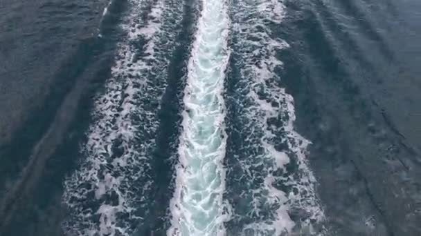 Bateau à moteur navigue le long de la baie de Kotor laissant un sentier mousseux. Un drone — Video