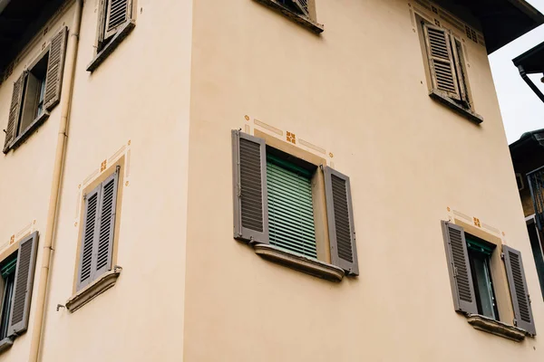 Fachada de uma casa velha com persianas nas janelas na cidade de Varenna — Fotografia de Stock