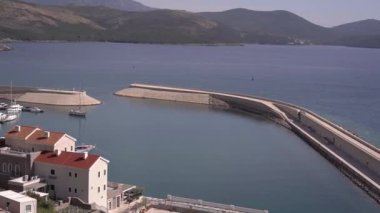 Dağların arka planına karşı Lustica Körfezi marinasının panoraması