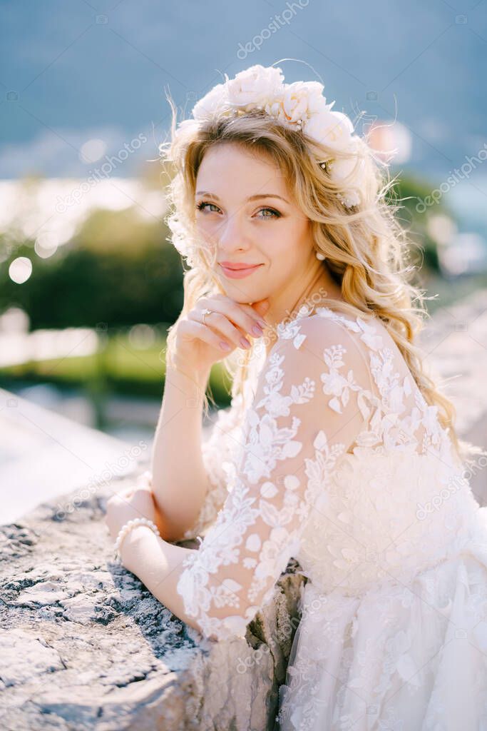 Beautiful blonde smiling bride in a white wreath, close-up 
