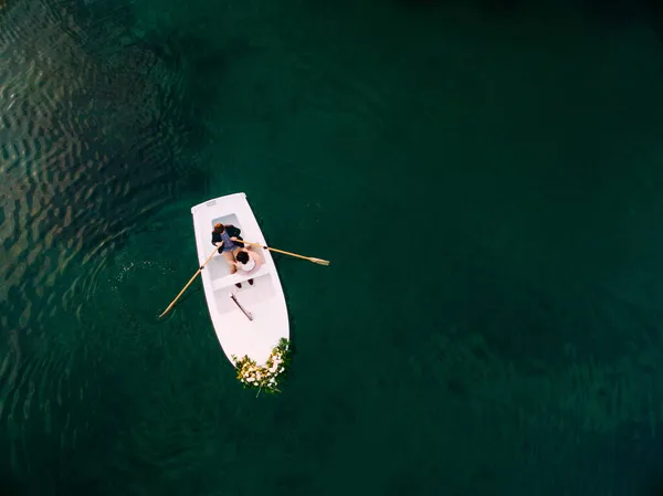 Hombre rueda mujer en un barco decorado con flores. Vista aérea — Foto de Stock