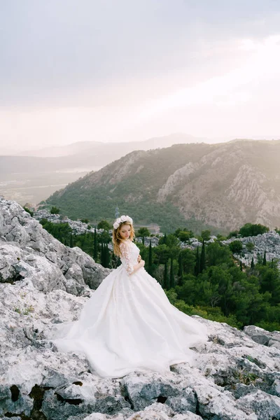 The bride stands on the rocks in the picturesque mountains in Montenegro — Stock Photo, Image