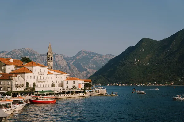 Perast binalarının arka planında tekneleri olan iskele. Karadağ
