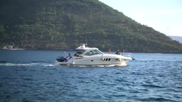 Yacht bianco naviga sul mare sullo sfondo delle montagne. Perast, Montenegro — Video Stock
