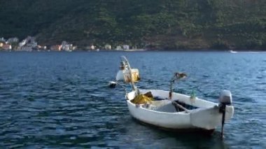 Perast sahilindeki dalgalarda kayık sallanıyor. Karadağ
