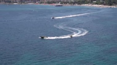 Motorlu tekne, körfezin karşısında turistlerle dolu şişirilebilir bir hap taşıyor.