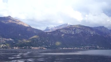 Como Gölü 'ndeki dalgalar, dağların arka planına karşı. İtalya