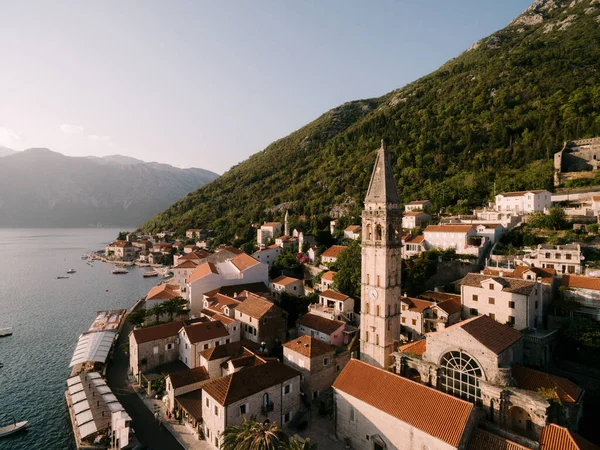 Aziz Niklas Kilisesi 'nin çan kulesi Perast' taki eski evlerin arasında. Karadağ