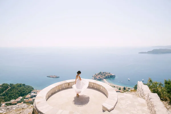 A noiva girando no deck de observação com vista para a ilha de Sveti Stefan, vista para trás — Fotografia de Stock