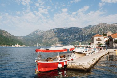 Tekneler Perast kıyısındaki Kotor Körfezi 'ndeki iskeleye demirlemiş durumda. Karadağ