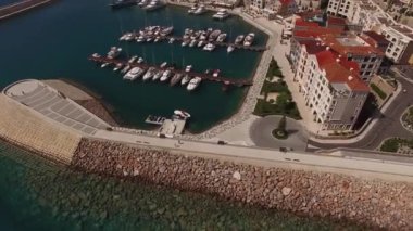Dalgaların ve rıhtımların Lustica Körfezi 'nde demirli yatları olan insansız hava aracı görüntüsü.