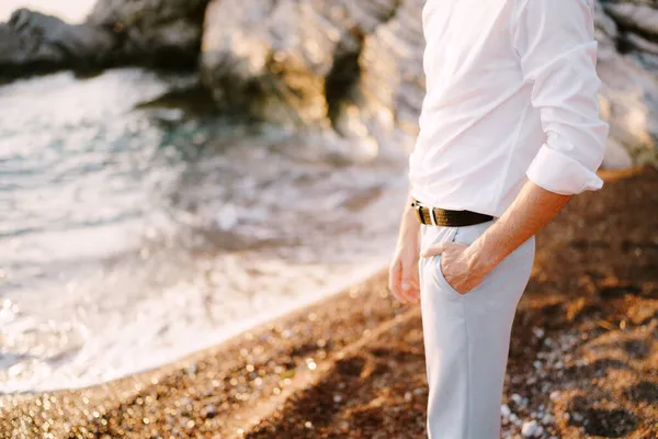 Brilho em uma camisa branca fica na costa arenosa junto ao mar — Fotografia de Stock