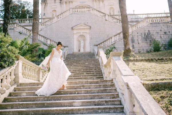 Nevěsta ve věži sestupuje po malebných schodech starobylého chrámu v Prcanji, pohled zezadu — Stock fotografie