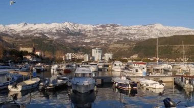 Budva 'daki liman karlı dağların arka planına karşı