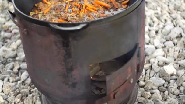 Estofado de zanahorias con carne para pilaf uzbeko en un caldero en una estufa — Vídeos de Stock